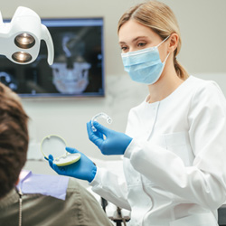 Dentist showing patient clear aligner in treatment room