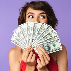 Woman holding up a fan of bills